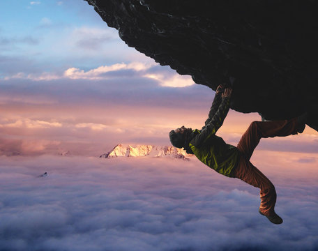 male rock climber. rock climber climbs on a black rocky wall on the ocean bank in Iceland, Kirkjufjara beach. man makes hard move without rope.