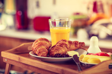 Breakfast on little table, orange juice croissant