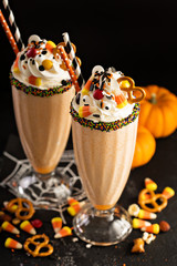 Halloween pumpkin milkshake decorated with candy