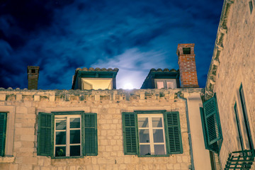 Fototapeta na wymiar moon rising behind a building in dubrovnik