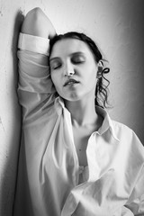 sensual sad young woman posing near wall, monochrome