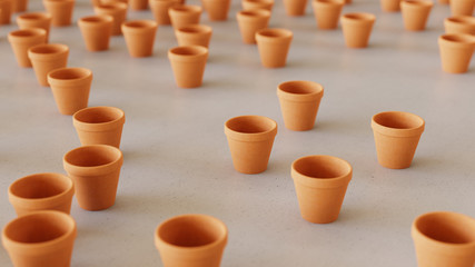 orange terracotta pots scattered on a white surface with shallow depth of field