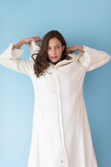 Naklejka premium woman in a white coat with hood isolated on blue background