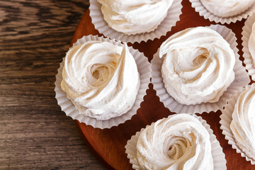  white marshmallows (zephyr) on a round wooden board