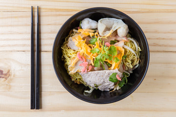 Chinese egg noodles and pork on wood table