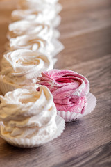 pink and white homemade marshmallows on a gray wooden background.