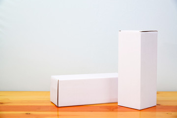 Empty two Package white cardboard box for long items on wooden table with copy space.