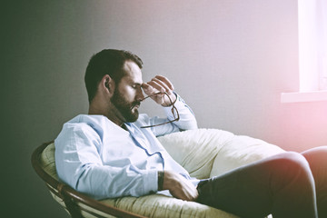 Stressed businessman in glasses having break