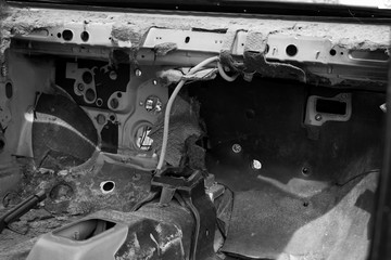 Destroyed abandoned car on the inside, black and white photo