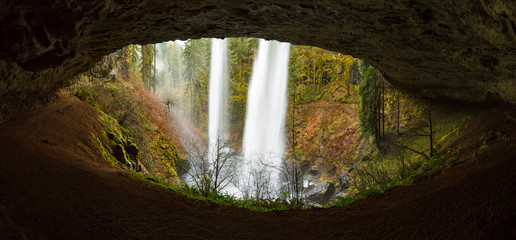 View of a waterfall from behind through an eye shaped cave
