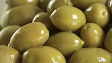 Large shiny green olives macro background