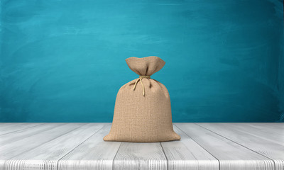 3d rendering of a blank tied up hessian bag full of money standing on a wooden surface on blue background.