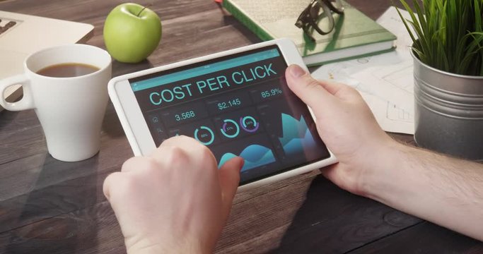 Monitoring cost per click records using digital tablet at desk