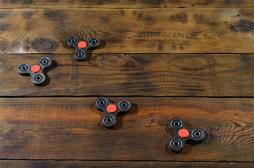 A rare handmade wooden fidget spinners lies on a brown wooden background surface. Trendy stress...