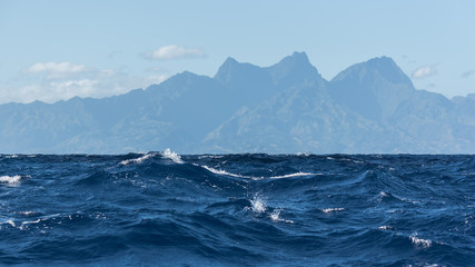 View of Tahiti from the sea in a windy day, foam and waves
