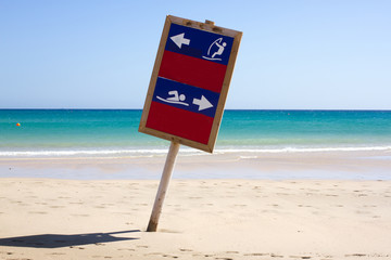 Wooden shield dug into sand. Way to swim and wind surfing