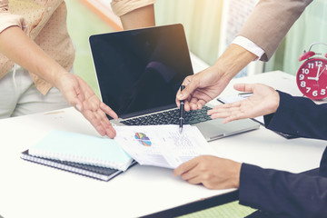 Team work look at spreadsheet data to find out a solution.