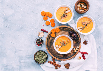 Obraz na płótnie Canvas Fresh homemade carrot, pumpkin, sweet potato soup in white bowl