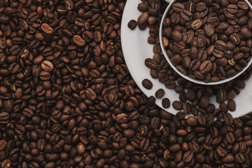 White cup with coffee beans. Coffee in beans macro. Abstract background texture.Coffee beans texture. Food background of coffee beans