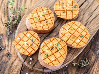 Baked batata on the old wooden table.