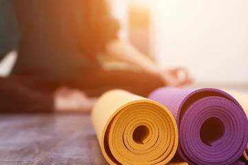 Photo sur Plexiglas École de yoga Vue rapprochée du tapis de yoga et de la femme en arrière-plan