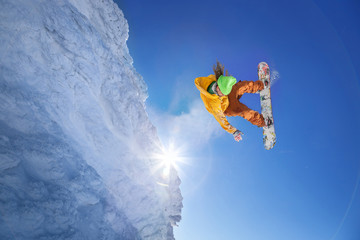 Obraz na płótnie Canvas Snowboarder jumping against blue sky