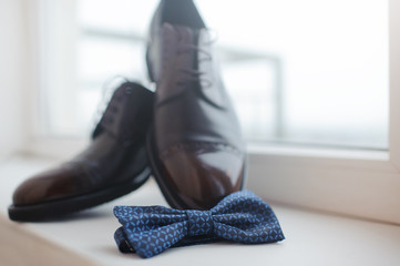Close-up of mens shoes and a bow tie.