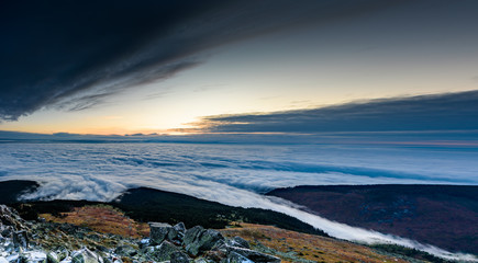 Cloud inversion from a mountain top - beautiful autumn landscape with thick blanket of rolling...