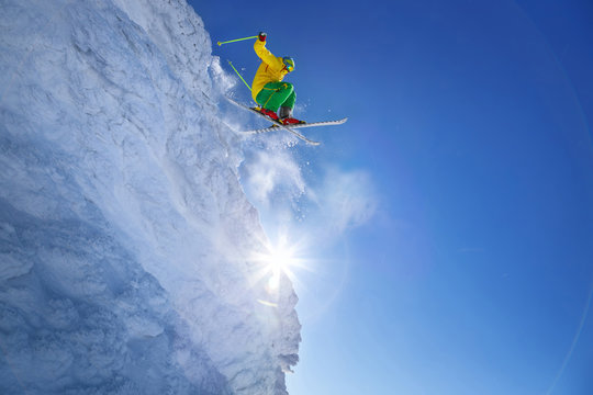 Skier jumping against blue sky from the rock