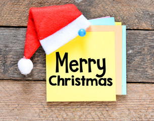 Merry Christmas inscription on a card with Santa's hat.