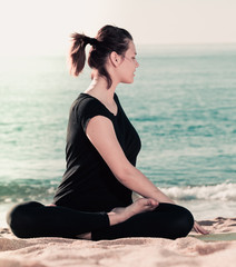 Smiling adult female in black T-shirt is practicing set of stretching exercises