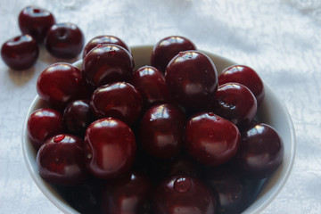 cherries on a white plate and white tablecloth