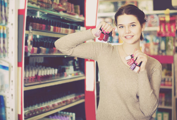 female customer looking for nail polish in cosmetics shop
