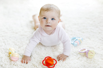 Cute baby girl playing with colorful pastel vintage rattle toy