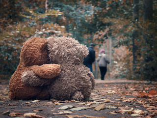 Two Teddy bear hugging each other and watch out for the road an elderly couple of people - grandparents