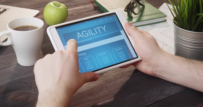 Looking at agility internet page using digital tablet at desk