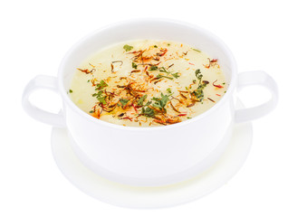 Vegetable soup with saffron in white bowl