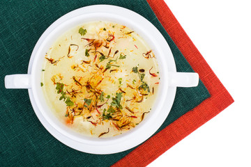 Vegetable soup with saffron in white bowl