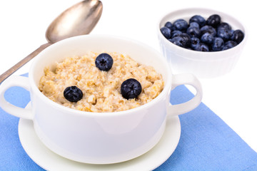 Healthy food. Oatmeal porridge with blueberries on blue napkin