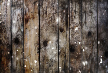 Background of wooden boards with snow and glitter bokeh effect.
