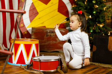 the little girl beats the drums. Studio shot.