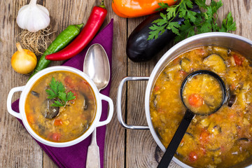 Rural dinner with soup and vegetables on wooden table