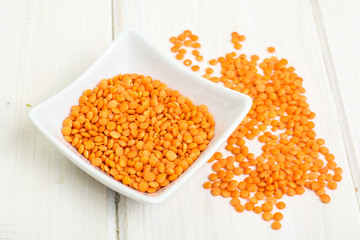 Red lentils on white wooden background