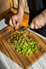 Cooking pie with rhubarb. The chef cuts the rhubarb.