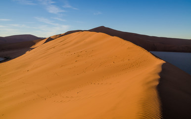 Fototapeta na wymiar Beautiful towering red sand dunes at famous Deadvlei near Sossusvlei in Namib desert, Namibia, Southern Africa