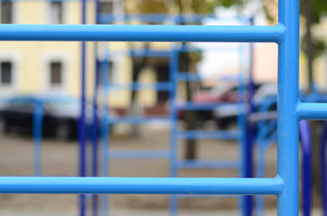 Blue metal pipes and cross-bars against a street sports field for training in athletics. Outdoor...