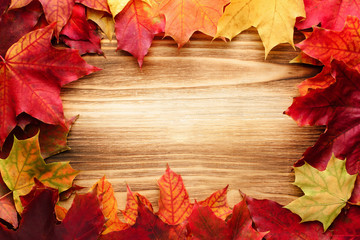 Naklejka na ściany i meble leaves frame as a background. Autumn leaves on wooden background. Mapled autumn leaves