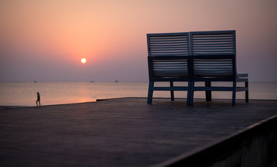 Orange Sunset beach at sea with one empty chair