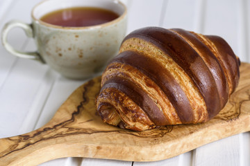 Fresh chocolate croissant on a wood traditional plate