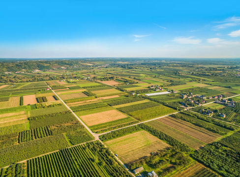 Fototapeta Krajobraz wiejski z lotu ptaka. Małe pola uprawne ciągnące się po horyzont.